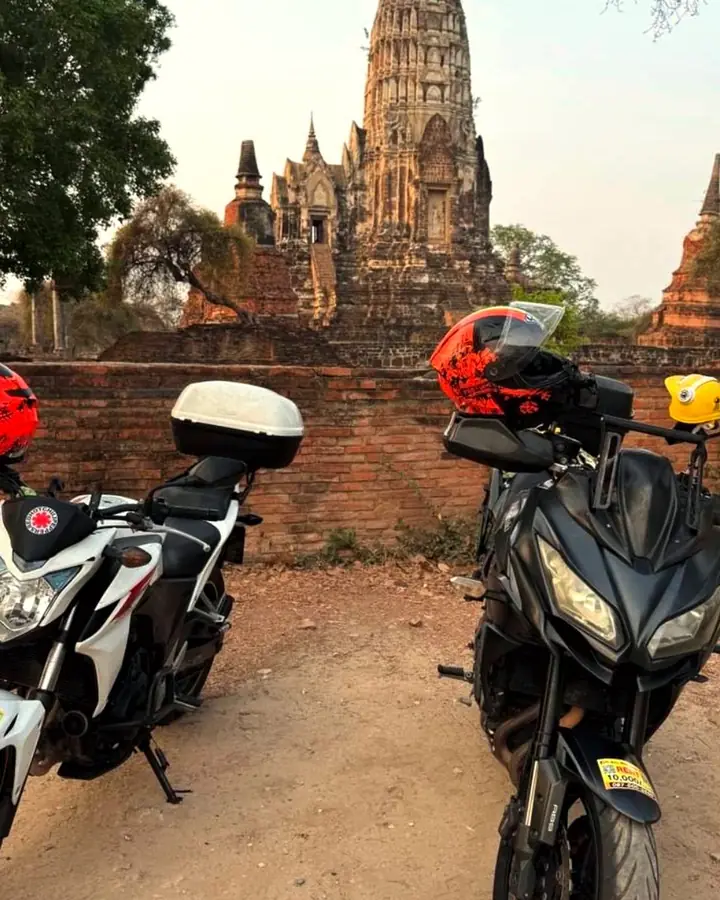 Two rental motorcycles in front of an old temple