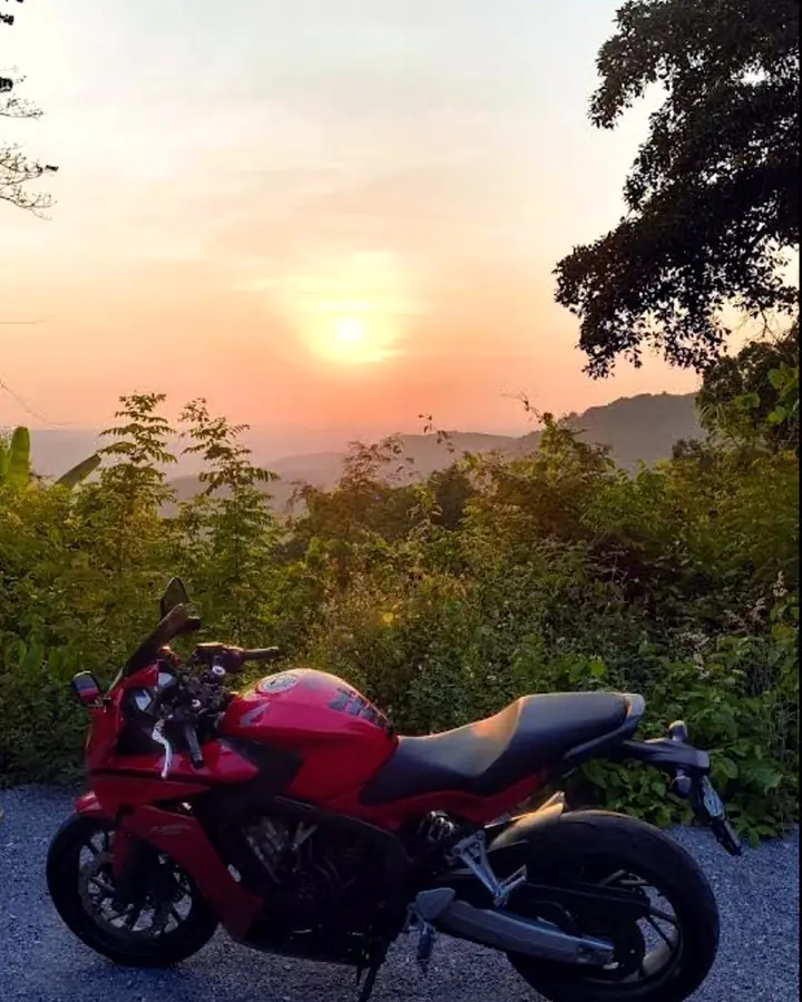 Red Honda CB650F at a mountain viewpoint at sunset